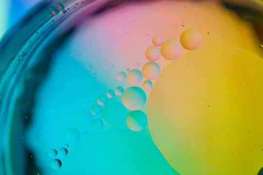 Fluid separation with colorful oil droplets forming abstract shapes in liquid