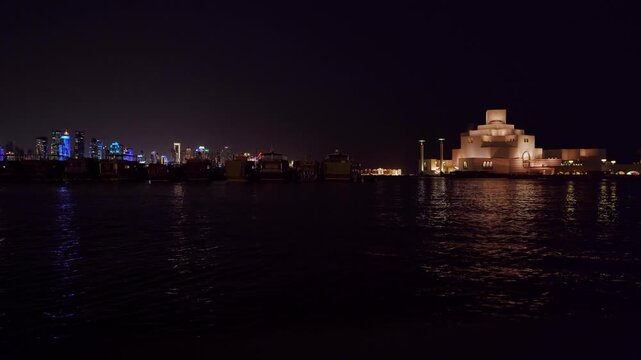 Doha, Doha Municipality, Qatar - 21 August 2026: View of the illuminated Museum of Islamic Art at night with the city skyline reflecting on the water.