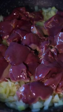Frying chopped chicken liver on a pan. Cooking process of preparing organic healthy food - fried chicken liver with onion.