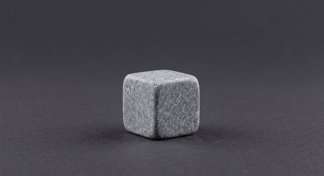 Natural gray soapstone whiskey chilling rock on dark paper