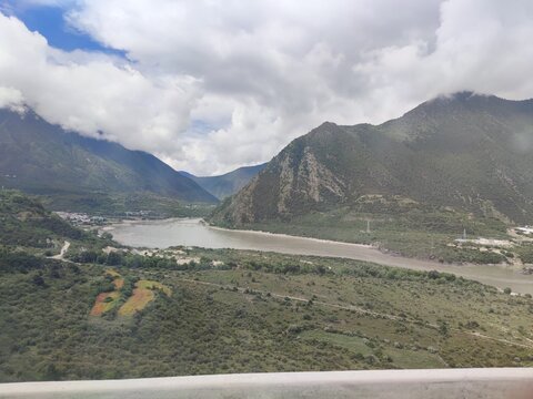 Elevated view of the Yarlung Tsangpo river confluence and the mountain village of Pai Town from a viewing platform in the Grand Canyon area, Nyingchi, Tibet, China