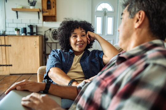 Mature couple talking on sofa at home
