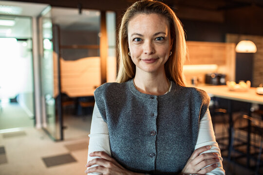 Confident businesswoman with crossed arms in modern office