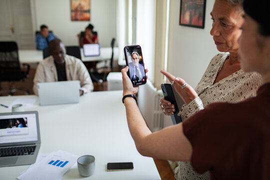 Coworkers discussing a video call in modern office