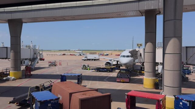 Texas, United States - 13 June 2025: View of an American Airlines aircraft parked at the gate at Dallas Fort Worth International Airport with ground support equipment.