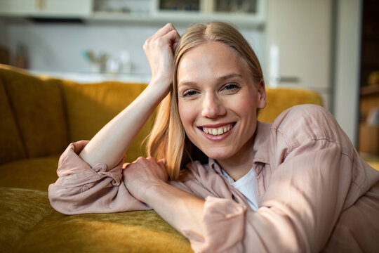 Smiling woman relaxing on sofa at home