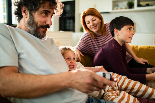Happy family playing video games together at home