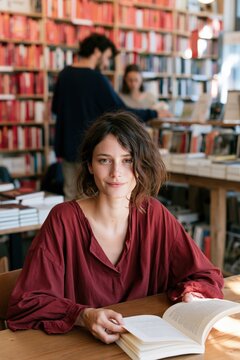 Young woman reading a book in a cozy bookshop natural portrait with soft light for lifestyle background use