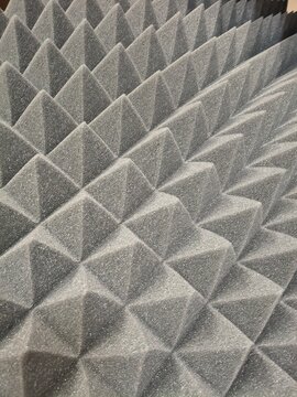 Black pyramid acoustic foam panel texture background, soundproof absorbing material surface for recording studio