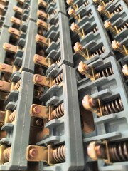 Obraz premium Electrical relay contact components with copper terminals and springs close up, industrial electronics texture background