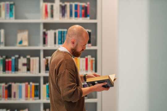Profile of a man reading a book in a quiet library