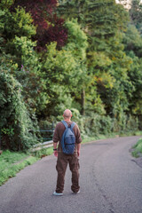 Fototapeta premium Rear view of a man standing alone on an empty country road