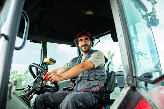Male farmer operating tractor in rural field