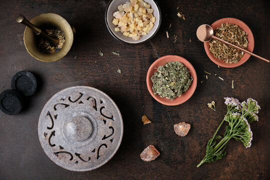 Incense ritual preparation with frankincense, dried herbs, incense burner, charcoal