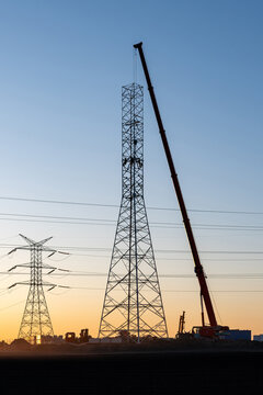 High Voltage Pylon Installation During Golden Hour