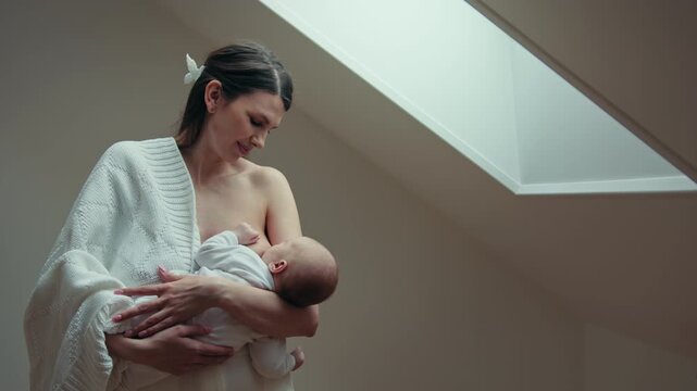 Mother lovingly nurses newborn baby fostering deep bond and connection during intimate moment. Woman parent child family love parenthood maternity cozy home adorable moment childhood innocence