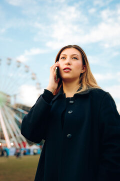 Young woman answering call at carnival
