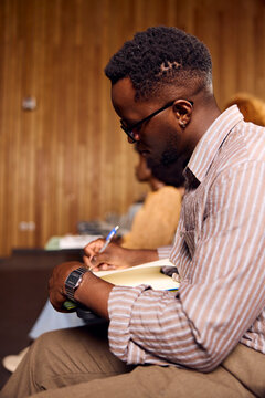 Man Taking Notes During an Event in a Conference Hall