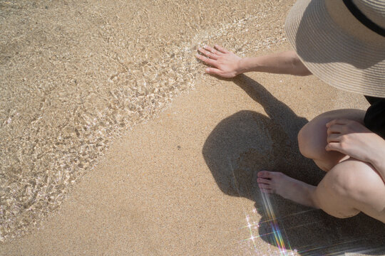 Woman Touching Gentle Waves on Sandy Beach