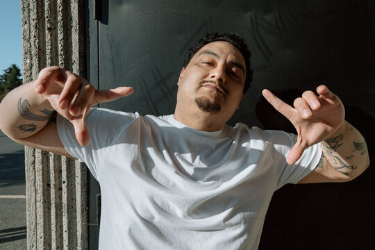 Candid portrait of a confident tattooed man in white t-shirt