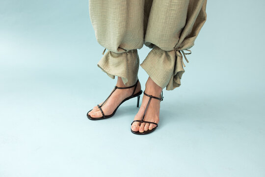 Close Up Detail of Sage Beige Linen Trousers and Black Strappy Sandals