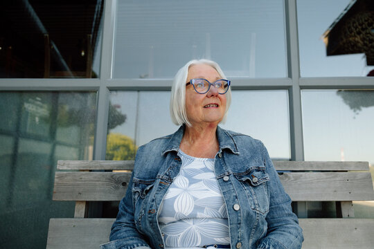 Candid portrait of a smiling senior woman sitting on a bench