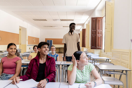 Diverse students laughing and interacting in a classroom