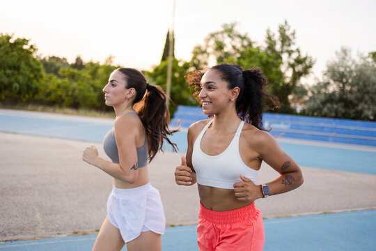 multiracial female athletes running on a track