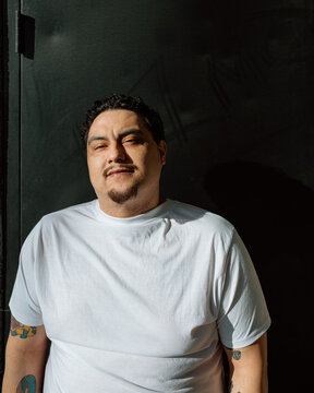 Candid portrait of a man in white t-shirt lit by warm sunlight