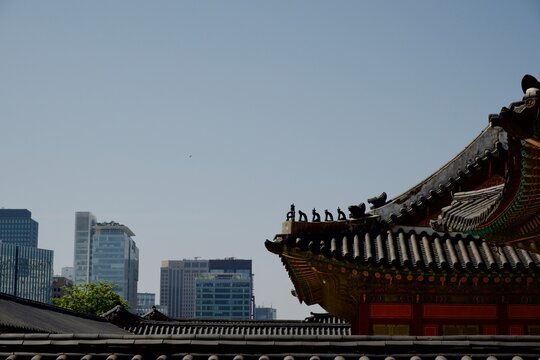 Traditional palace roof against modern city skyscrapers