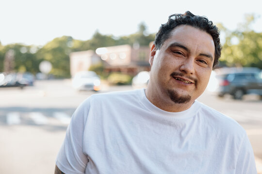 Candid outdoor portrait of a smiling man in white t-shirt