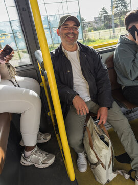 happy mature man commuting on public city transport