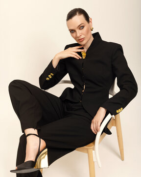A studio portrait of a woman sitting on the chair.