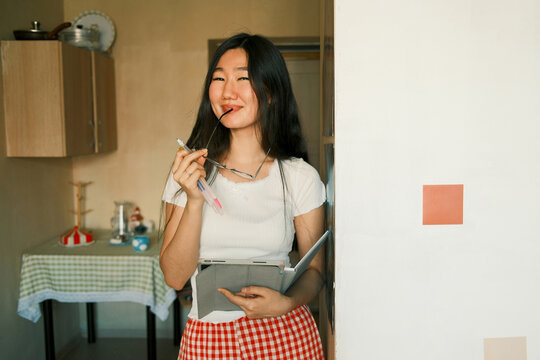 Young happy asian female student holding a tablet, education concept 