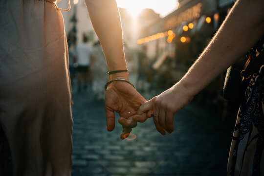 Couple Holding Hands in a Busy Street at Sunset