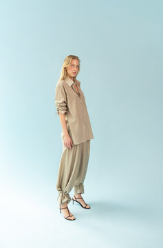Portrait of Blonde Model in Stone Beige Linen Shirt on Blue Background