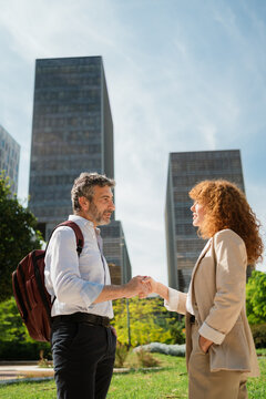 Man and Woman Shaking Hands to Finalize Agreement Outside Office