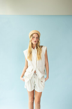 Fashion Portrait of Blonde Model Wearing Straw Hat on Blue Background