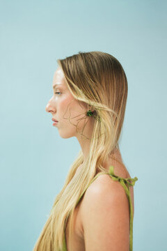 Beauty Profile of Blonde Woman in Green Dress and Floral Earring
