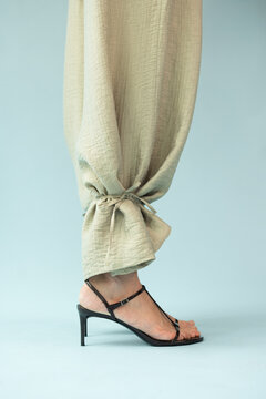 Close Up Detail of Sage Beige Linen Trousers and Black Strappy Sandals