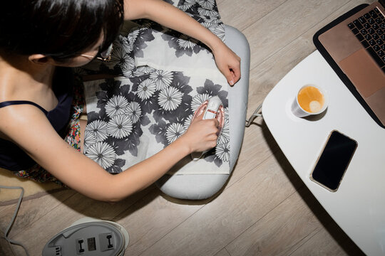 Woman Ironing Fabric While Working From Home