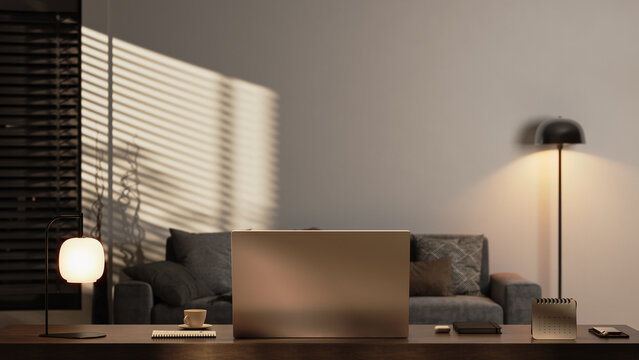 Modern home office workspace with laptop and warm evening lighting