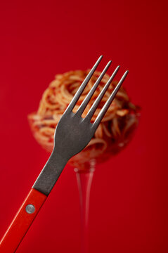 Conceptual food photography: fork in focus with bokeh pasta
