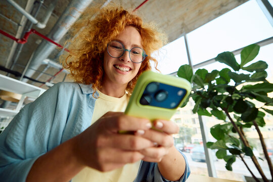 Young woman uses her mobile phone inside the university building