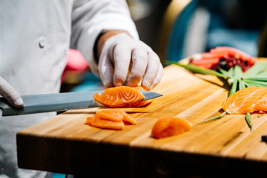 Sushi chef slices salmon