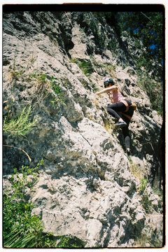 Climber Ascends Rocky Cliff 