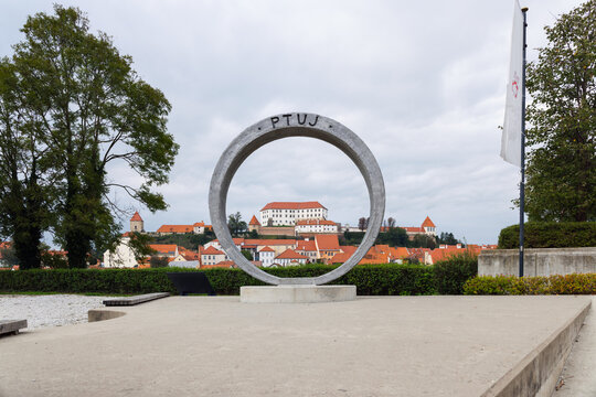 Visitors view Ptuj Castle from a circular monument ring near the Drava River in Slovenia. The town is a popular destination for tourists.