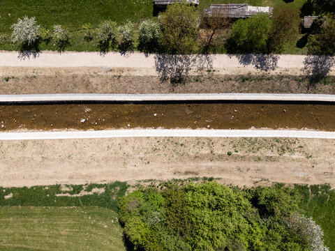 Drone view of a river restoration project. Workers clean and widen the river channel for better flood prevention and management.