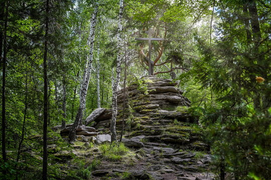 Orthodox cross on a mountain of stones in a dense forest on Vera Island, Chelyabinsk region of Russia