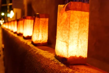 A row of luminaries are lit up on a ledge, creating a warm and inviting atmosphere. © Pete Niesen Photo
